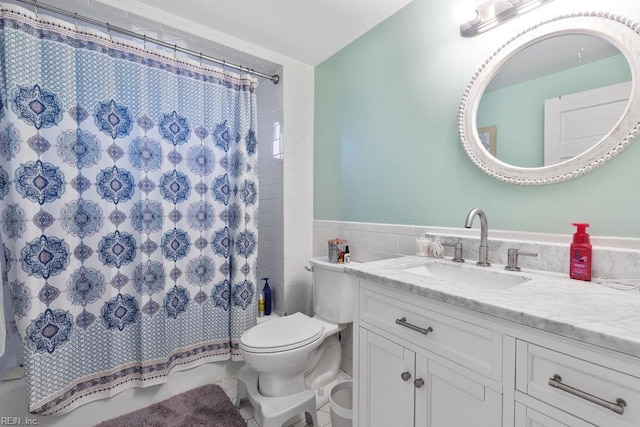 2766 Mckann Ave, Norfolk, VA 23509 - full bathroom with vanity, toilet, tile walls, tile patterned flooring, and a wainscoted wall