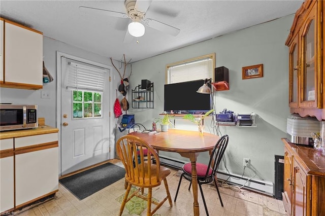 4420 Anderson Ave, Suffolk, VA 23435 - dining room featuring light floors, a baseboard heating unit, a ceiling fan, and a textured ceiling
