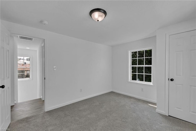1604 Freeney Ave, Suffolk, VA 23434 - empty room featuring carpet, plenty of natural light, a smoke detector, and baseboards