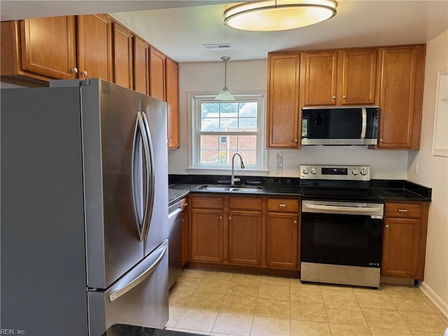 2 Yulee Ct, Hampton, VA 23669 - kitchen featuring appliances with stainless steel finishes, a sink, brown cabinets, light tile patterned floors, and pendant lighting