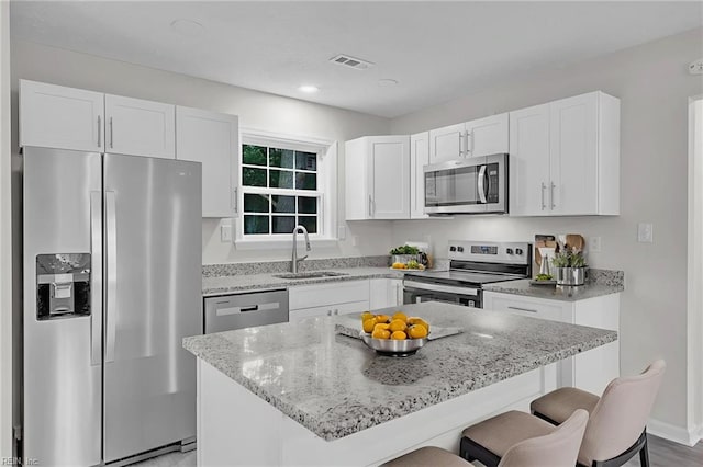 608 N Pine Grove Rd, Virginia Beach, VA 23452 - kitchen featuring appliances with stainless steel finishes, a sink, a breakfast bar, light stone counters, and recessed lighting