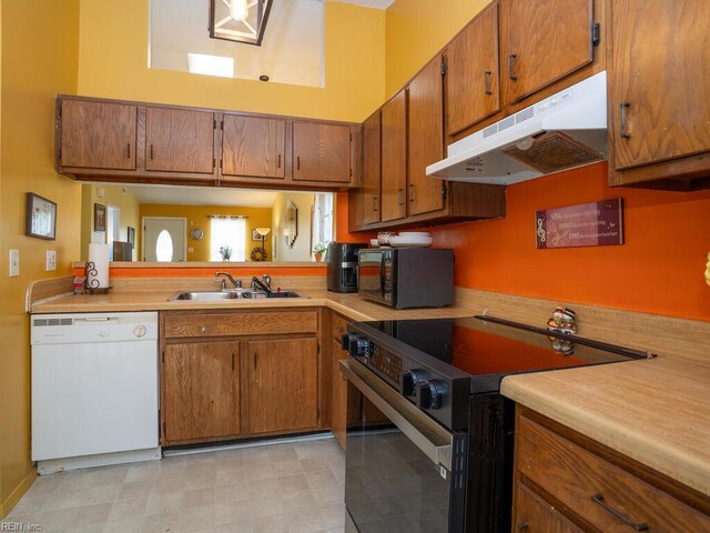 808 Dora Ct, Virginia Beach, VA 23455 - kitchen featuring black appliances, under cabinet range hood, a sink, brown cabinets, and a high ceiling