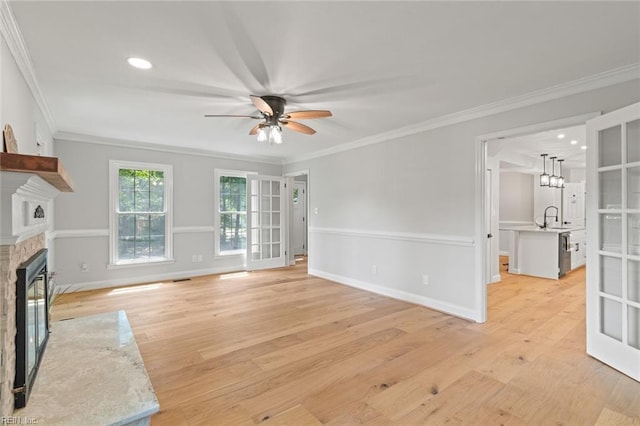 1756 Tyndall Point Rd, Gloucester Point, VA 23062 - unfurnished living room featuring ceiling fan, light wood-type flooring, ornamental molding, a glass covered fireplace, and a sink