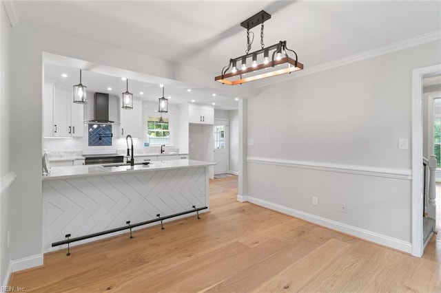 1756 Tyndall Point Rd, Gloucester Point, VA 23062 - kitchen with wall chimney exhaust hood, a sink, white cabinets, light wood-style floors, and a peninsula