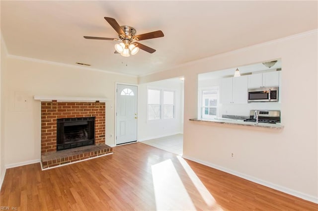1582 Sword Dancer Dr, Virginia Beach, VA 23454 - unfurnished living room featuring ornamental molding, ceiling fan, light wood finished floors, baseboards, and a brick fireplace