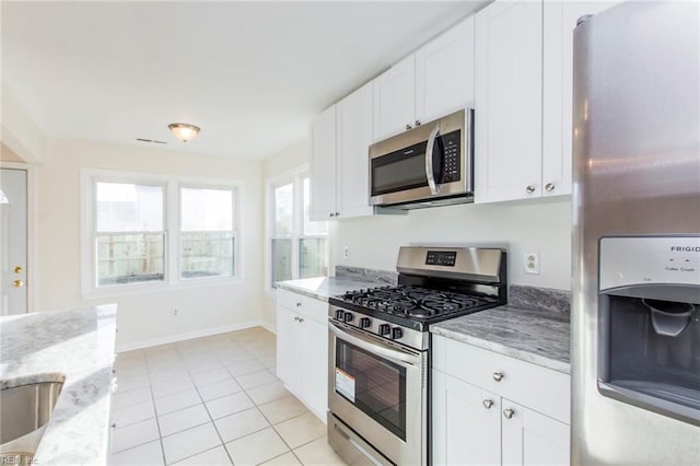 1582 Sword Dancer Dr, Virginia Beach, VA 23454 - kitchen featuring appliances with stainless steel finishes, light tile patterned flooring, light stone countertops, and white cabinetry