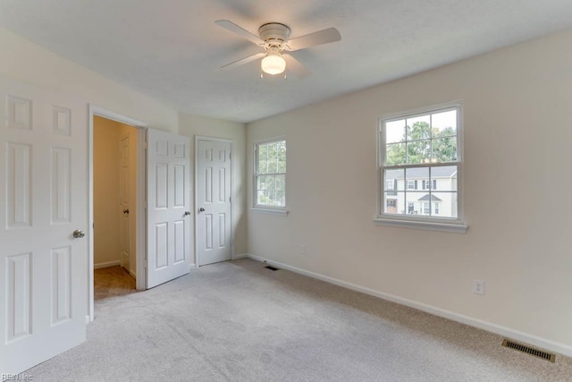 1603 Skiffes Creek Cir, Williamsburg, VA 23185 - unfurnished bedroom with multiple windows, light colored carpet, and baseboards