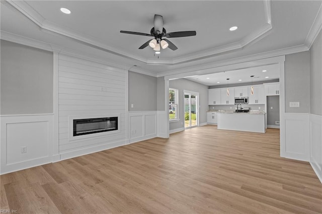 4 Roundtree Cir, Hampton, VA 23661 - unfurnished living room with a decorative wall, a ceiling fan, light wood-style floors, crown molding, and a tray ceiling