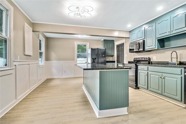 112 Atwell Ln, Hampton, VA 23669 - kitchen featuring appliances with stainless steel finishes, a kitchen island, a sink, light wood finished floors, and wainscoting