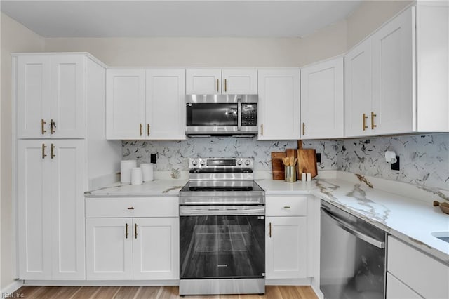 2920 Fetsch Pl, Virginia Beach, VA 23453 - kitchen with appliances with stainless steel finishes, white cabinets, decorative backsplash, light wood-type flooring, and light stone counters