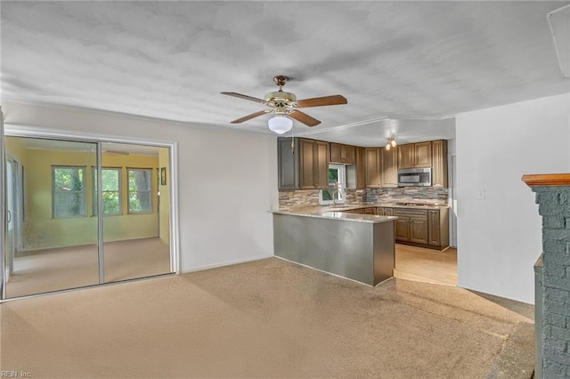 8248 Andrew Ln, Norfolk, VA 23505 - kitchen featuring stainless steel microwave, light carpet, decorative backsplash, and a ceiling fan