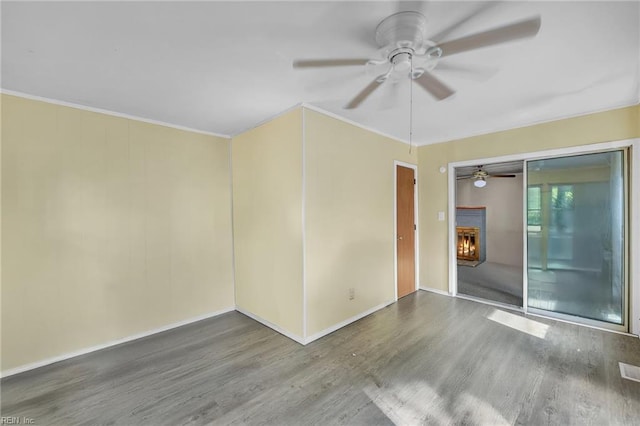 8248 Andrew Ln, Norfolk, VA 23505 - empty room featuring wood finished floors, a ceiling fan, a lit fireplace, ornamental molding, and baseboards