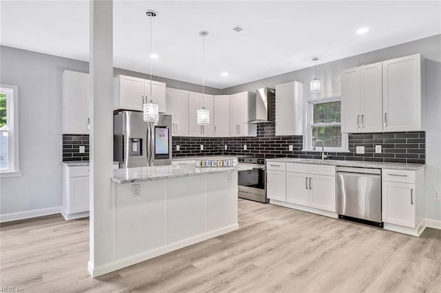 3502 Goodwin Neck Rd, Yorktown, VA 23692 - kitchen with stainless steel appliances, wall chimney range hood, a sink, light wood finished floors, and healthy amount of natural light