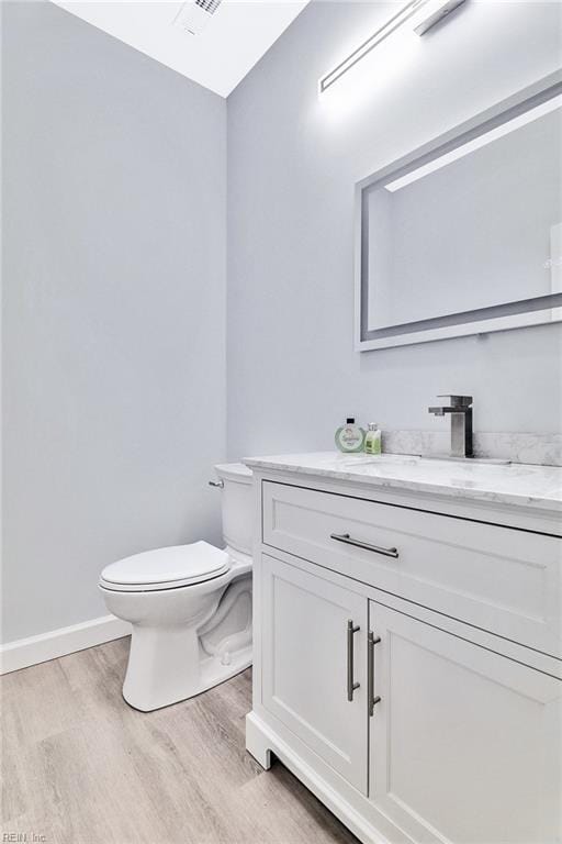 3502 Goodwin Neck Rd, Yorktown, VA 23692 - half bathroom featuring wood finished floors, vanity, toilet, and baseboards