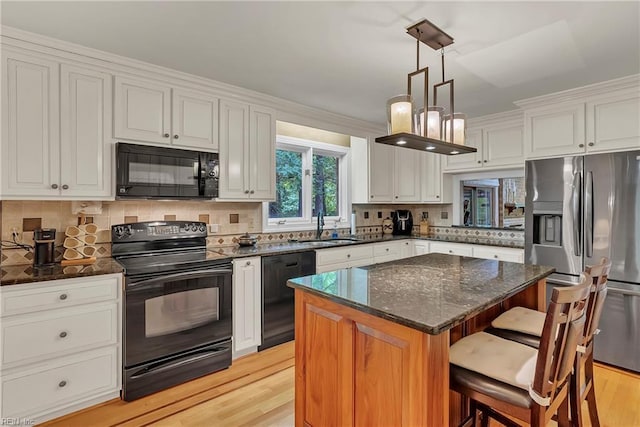 928 S Spigel Dr, Virginia Beach, VA 23454 - kitchen with black appliances, a kitchen breakfast bar, a sink, and decorative backsplash