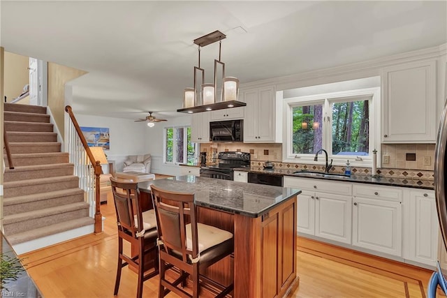 928 S Spigel Dr, Virginia Beach, VA 23454 - kitchen featuring black appliances, a sink, light wood-style floors, ceiling fan, and white cabinetry