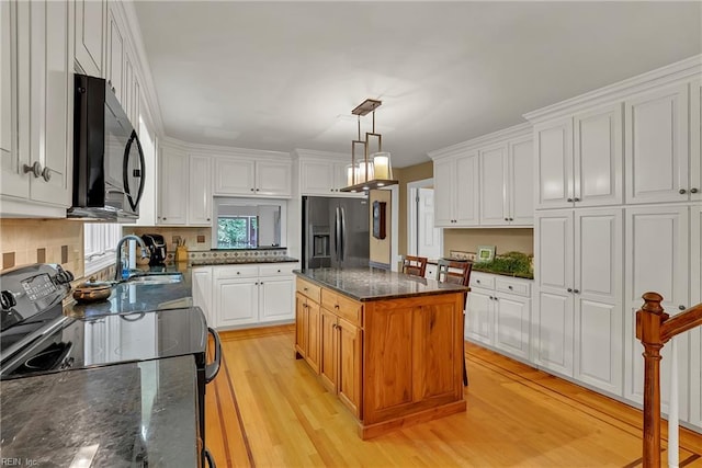 928 S Spigel Dr, Virginia Beach, VA 23454 - kitchen with black appliances, a sink, white cabinetry, light wood-style floors, and a kitchen island