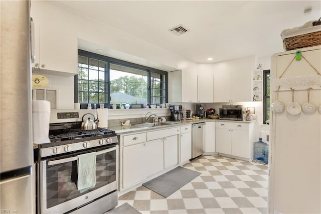 1301 Penguin Cir, Virginia Beach, VA 23451 - kitchen with appliances with stainless steel finishes, light flooring, light countertops, white cabinetry, and open shelves
