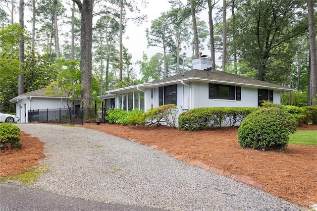1301 Penguin Cir, Virginia Beach, VA 23451 - ranch-style home featuring a chimney, gravel driveway, view of scattered trees, and brick siding