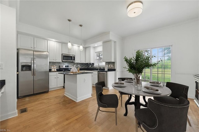 5308 Doral Woods Ct, Suffolk, VA 23435 - kitchen with stainless steel appliances, dark countertops, decorative backsplash, crown molding, and light wood finished floors
