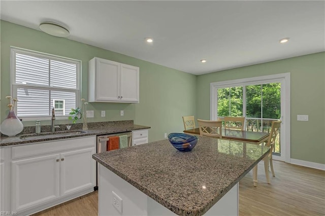 6945 Healy Ave, Gloucester, VA 23061 - kitchen with a sink, light wood-style flooring, dark stone countertops, a center island, and white cabinets