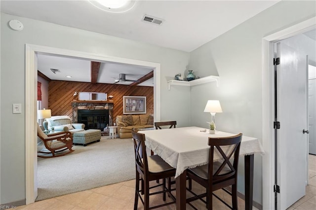 2004 Convoy Ct, Virginia Beach, VA 23454 - dining area with wood walls, light colored carpet, a ceiling fan, light tile patterned floors, and a stone fireplace