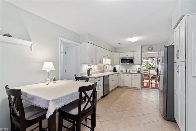 2004 Convoy Ct, Virginia Beach, VA 23454 - kitchen with stainless steel appliances, white cabinetry, light countertops, and light tile patterned flooring
