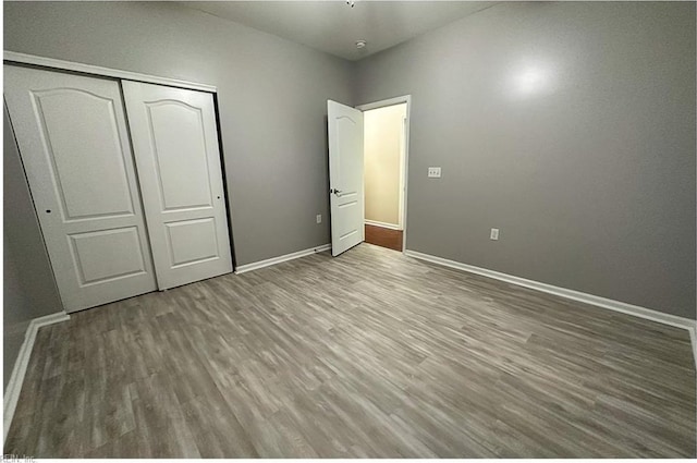 932 Southmoor Dr Unit 105, Virginia Beach, VA 23455 - unfurnished bedroom featuring baseboards, wood finished floors, and a closet