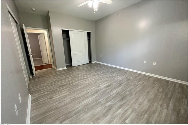 932 Southmoor Dr Unit 105, Virginia Beach, VA 23455 - unfurnished bedroom featuring wood finished floors, baseboards, ceiling fan, and a closet