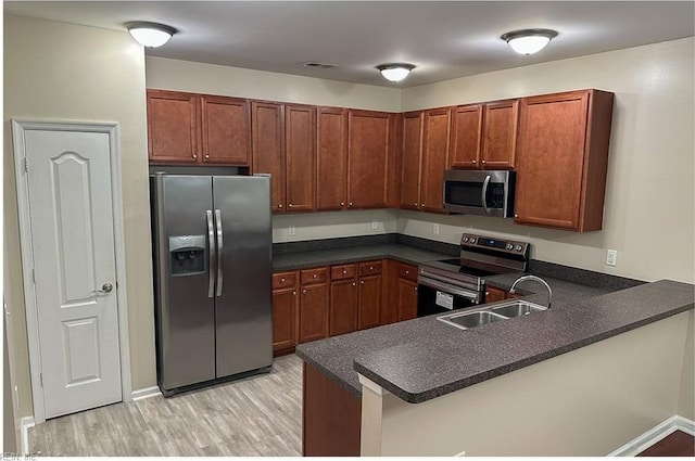 932 Southmoor Dr Unit 105, Virginia Beach, VA 23455 - kitchen featuring appliances with stainless steel finishes, a sink, dark countertops, and light wood-type flooring