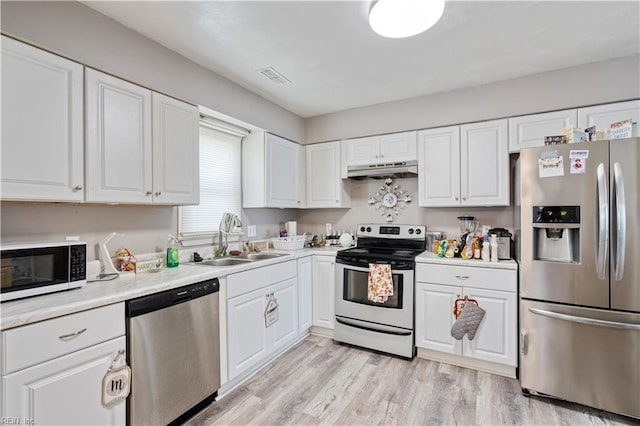 5425 Sweetwater Ct, Virginia Beach, VA 23462 - kitchen featuring stainless steel appliances, under cabinet range hood, white cabinets, light countertops, and light wood-type flooring
