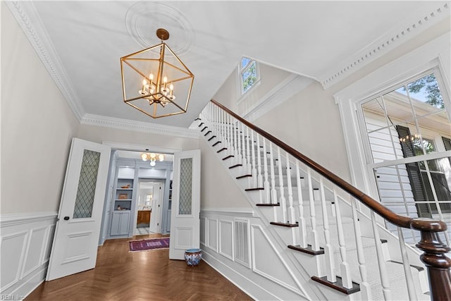 2652 Benefit Rd, Chesapeake, VA 23322 - stairway featuring a chandelier, plenty of natural light, wainscoting, a decorative wall, and crown molding