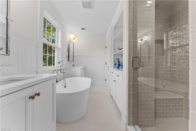 2652 Benefit Rd, Chesapeake, VA 23322 - bathroom featuring wainscoting, two vanities, a stall shower, a freestanding bath, and tile patterned flooring
