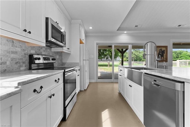 2652 Benefit Rd, Chesapeake, VA 23322 - kitchen with appliances with stainless steel finishes, crown molding, tasteful backsplash, white cabinetry, and concrete flooring