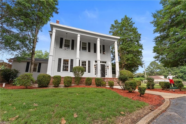 2652 Benefit Rd, Chesapeake, VA 23322 - greek revival house featuring a front yard, a porch, and a chimney