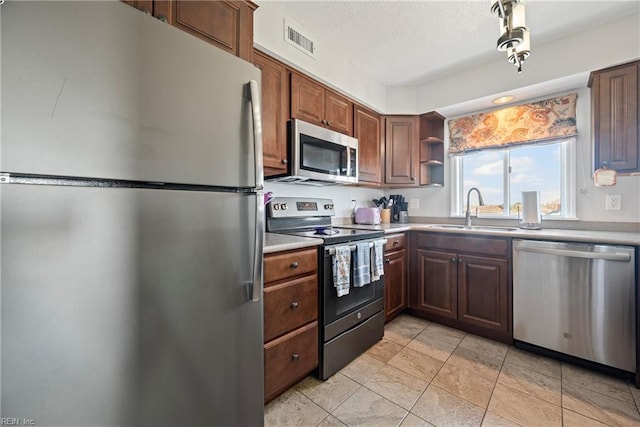7501 River Rd Unit 4A, Newport News, VA 23607 - kitchen featuring stainless steel appliances, a sink, light countertops, open shelves, and a textured ceiling