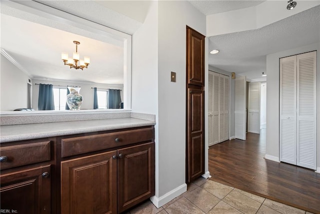 7501 River Rd Unit 4A, Newport News, VA 23607 - hallway featuring a chandelier, baseboards, light tile patterned floors, and a textured ceiling