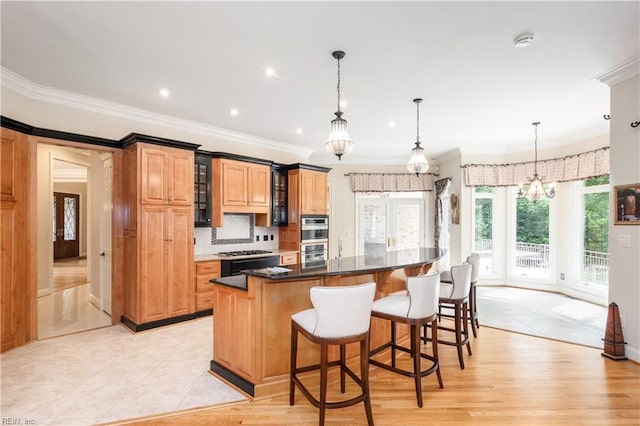 5225 Regatta Pointe Rd, Suffolk, VA 23435 - kitchen featuring double oven, a kitchen bar, glass insert cabinets, crown molding, and a spacious island