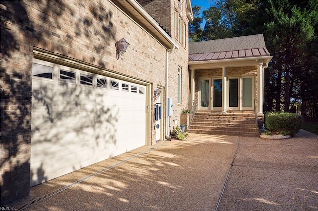 5225 Regatta Pointe Rd, Suffolk, VA 23435 - view of front of property featuring driveway, brick siding, an attached garage, a standing seam roof, and metal roof