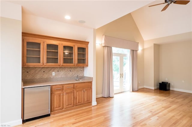 5225 Regatta Pointe Rd, Suffolk, VA 23435 - kitchen featuring fridge, brown cabinets, light countertops, decorative backsplash, and glass insert cabinets