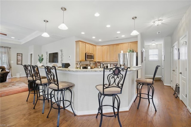 2972 Elegance Ln, Virginia Beach, VA 23456 - kitchen with stainless steel appliances, light brown cabinetry, a kitchen bar, light wood-type flooring, and recessed lighting