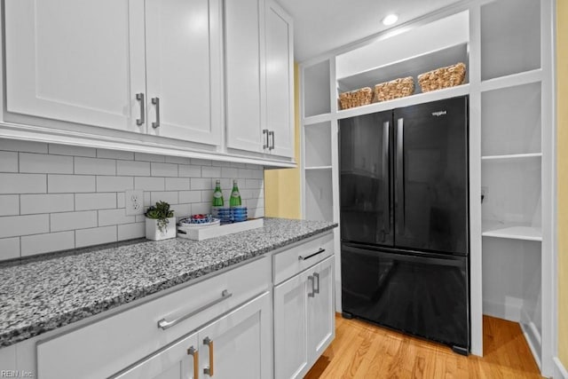 1405 Gravatt Ln, Virginia Beach, VA 23454 - kitchen featuring freestanding refrigerator, white cabinetry, light stone counters, backsplash, and light wood-style floors