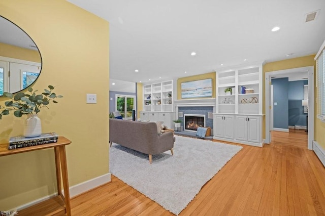 1405 Gravatt Ln, Virginia Beach, VA 23454 - living area featuring light wood finished floors, a glass covered fireplace, recessed lighting, and built in shelves