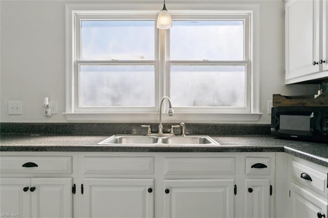 385 Susan Constant Dr, Newport News, VA 23608 - kitchen with black microwave, dark countertops, and white cabinetry
