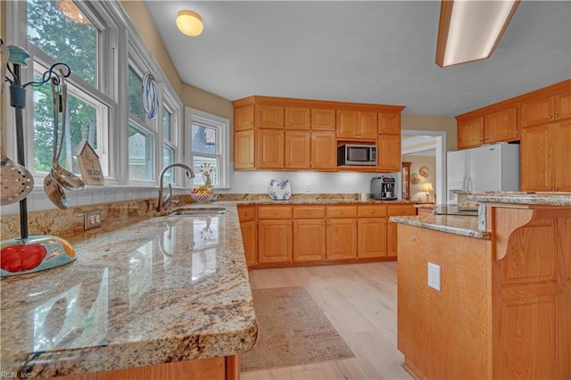 1832 Tree Line Rd, Virginia Beach, VA 23454 - kitchen with stainless steel microwave, white fridge with ice dispenser, light stone countertops, light wood-type flooring, and a breakfast bar