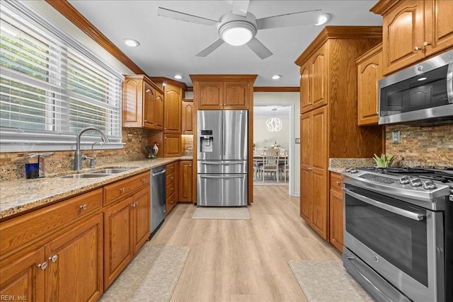 1309 Taft Rd, Chesapeake, VA 23322 - kitchen featuring stainless steel appliances, light stone counters, ornamental molding, brown cabinetry, and light wood-type flooring