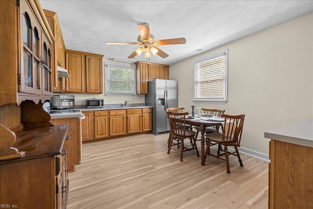 1309 Taft Rd, Chesapeake, VA 23322 - kitchen featuring appliances with stainless steel finishes, brown cabinetry, light wood-type flooring, and a ceiling fan