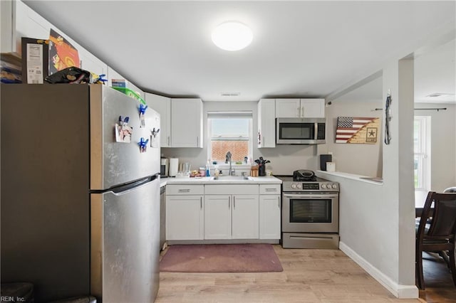 313 Saint James Ave, Suffolk, VA 23434 - kitchen with appliances with stainless steel finishes, light wood-style flooring, light countertops, and white cabinetry