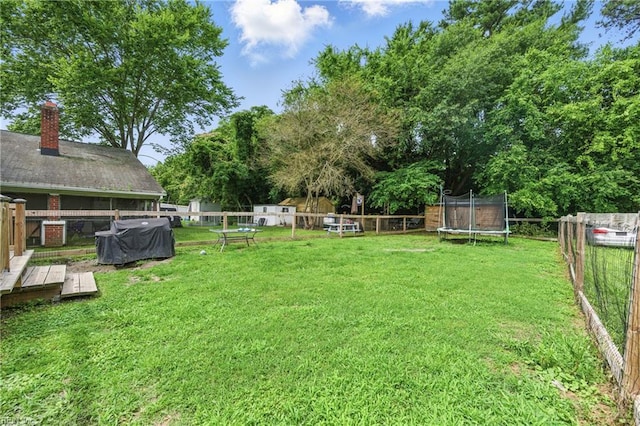 313 Saint James Ave, Suffolk, VA 23434 - fenced backyard featuring a trampoline, a deck, and view of scattered trees