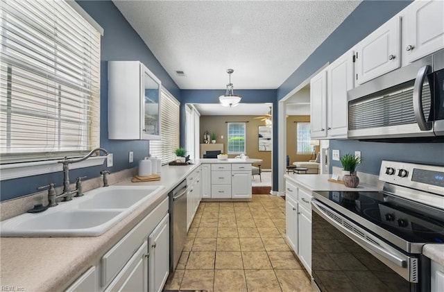 4 Angelia Way, Hampton, VA 23663 - kitchen with stainless steel appliances, light countertops, white cabinets, hanging light fixtures, and a textured ceiling